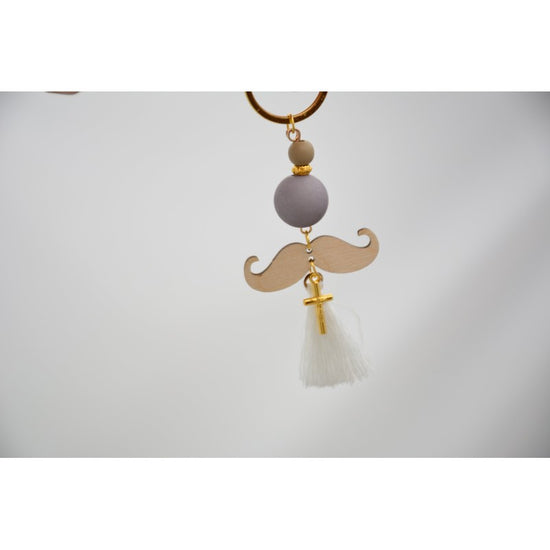 Μαρτυρικό μπρελόκ μουστάκι σε λευκό μπέζ αποχρώσεις , με φουντίτσα λευκή