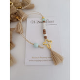 Μαρτυρικό μπεγλέρι σε αποχρώσεις λευκό-μπεζ-βεραμάν με ιδιαίτερο σταυρό και φουντίτσα