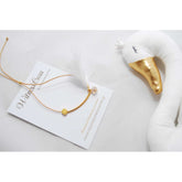 Μαρτυρικό βραχιόλι με ιδιαίτερο δέσιμο , πούπουλο, κρεμαστή μπίλια ροζ,  περαστό σταυρό σε χρυσό