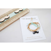 Μαρτυρικό βραχιόλι με μουστάκι σε μπεζ-βεραμάν, μουστάκι μαύρο με χρυσό σταυρό &amp; βεραμάν κορδέλα