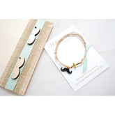 Μαρτυρικό βραχιόλι με μουστάκι σε μπεζ-βεραμάν, μουστάκι μαύρο με χρυσό σταυρό &amp; βεραμάν κορδέλα