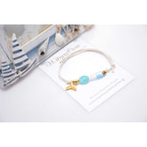 Μαρτυρικό βραχιόλι με ουρά γοργόνα, χάντρες, περαστό σταυρό χρυσό  & χάντρες σε σιέλ λευκό